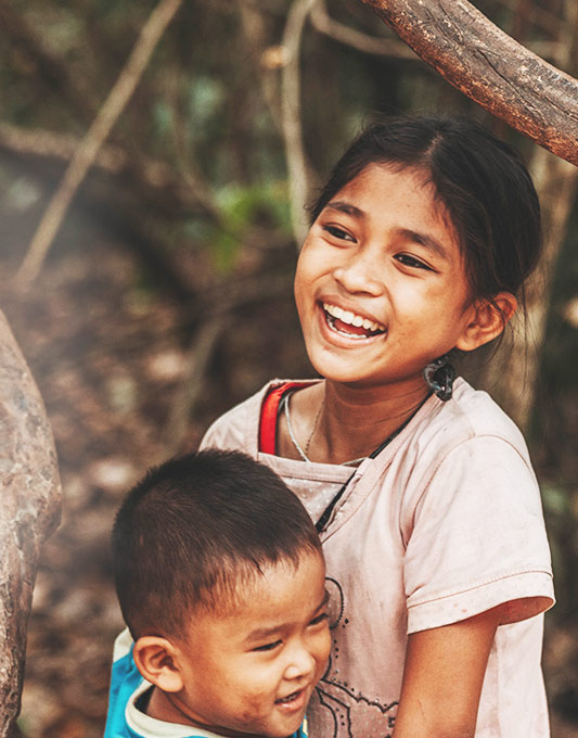 A young girl and boy smile for the camera.