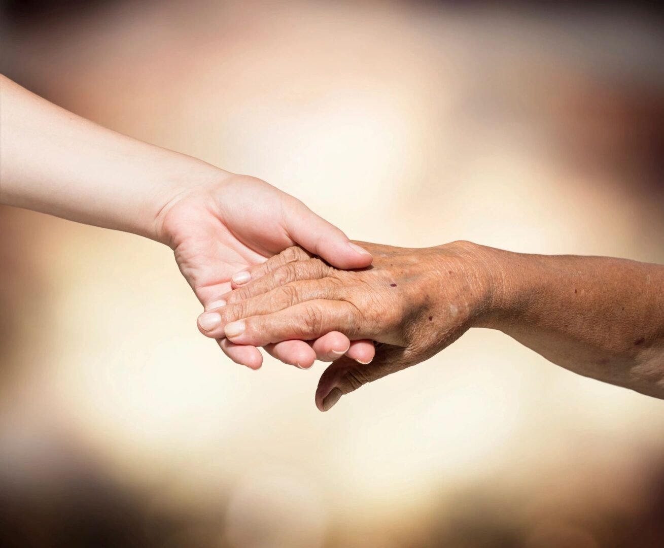 Two people holding hands in a close up picture.